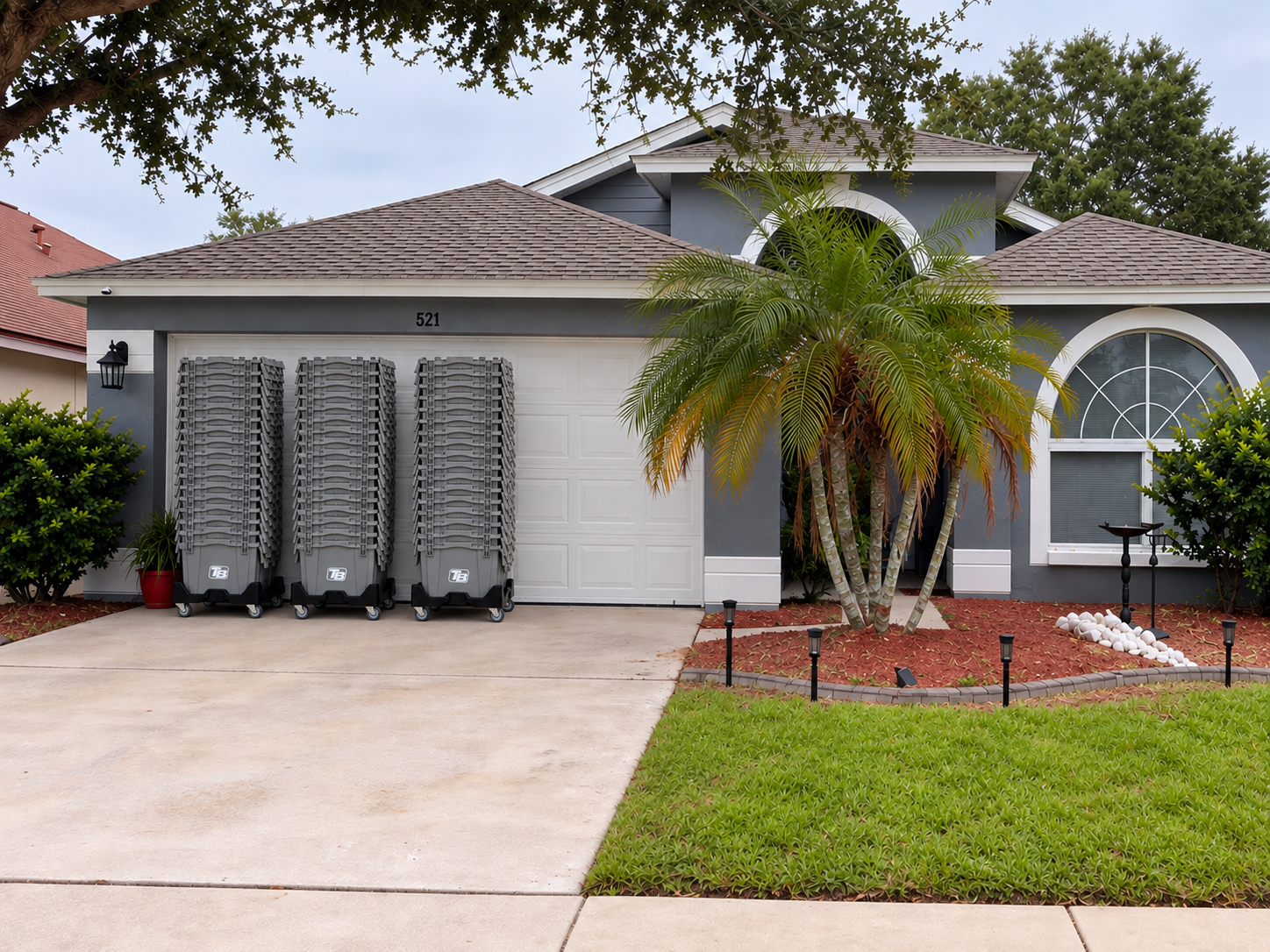 Three stacks of TB branded bins on dollies in front of Tampa home